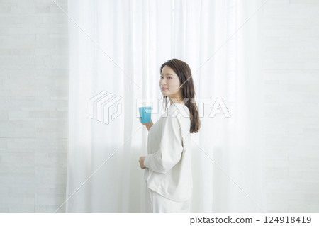 一個女人在一個房間裡喝咖啡 124918419
