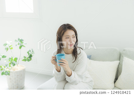 一個女人在一個房間裡喝咖啡 一個女人在一個房間裡喝咖啡 124918421