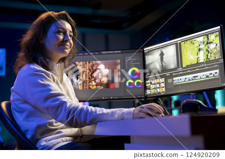 Happy videographer reviewing footage and selecting scenes, trimming them using specialized software applications and editing tools. Smiling video editor working for media company in editing room Happy videographer reviewing footage and selecting scenes, trimming them using specialized software applications and editing tools. Smiling video editor working for media company in editing room 124920209