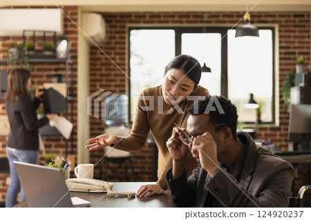 Male manager working with female employee, reviewing business documents and online data on laptop. Black man adjusting his glasses as asian businesswoman presents research statistics on digital device Male manager working with female employee, reviewing business documents and online data on laptop. Black man adjusting his glasses as asian businesswoman presents research statistics on digital device 124920237