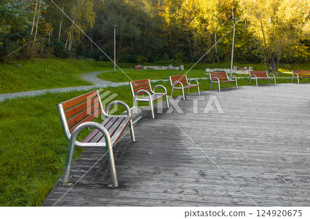 Wooden bench in the city park. Round benches in a tiled square in the city 124920675
