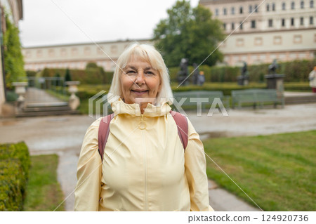 A female tourist walks around along a decorative alley decorated with many statues in a decorative park at Wallenstein Palace building in Prague in Czech Republic 124920736