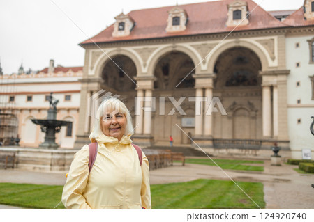 A female tourist walks around along a decorative alley decorated with many statues in a decorative park at Wallenstein Palace building in Prague in Czech Republic 124920740