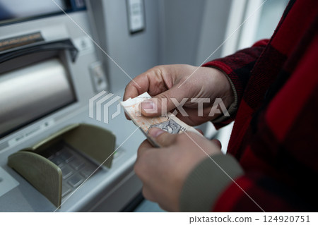 ATM Cash Withdrawal in Zloty, Man Taking Money from Cash Machine 124920751