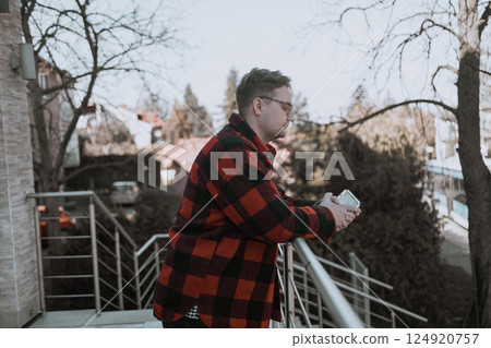 Young blond man with glasses looking at phone on street Young blond man with glasses looking at phone on street 124920757