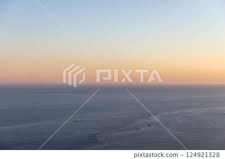 Peaceful view of the sea under a vivid sunrise sky Peaceful view of the sea under a vivid sunrise sky 124921328