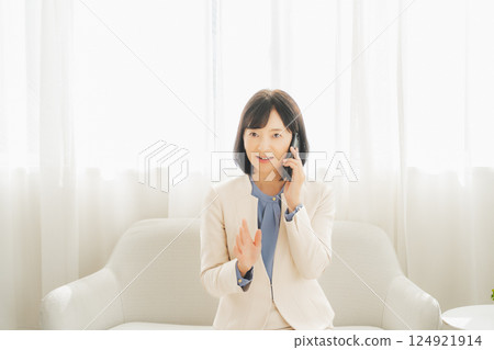 一位中年職業婦女用手勢與電話另一端的人交談 一位中年職業婦女用手勢與電話另一端的人交談 124921914