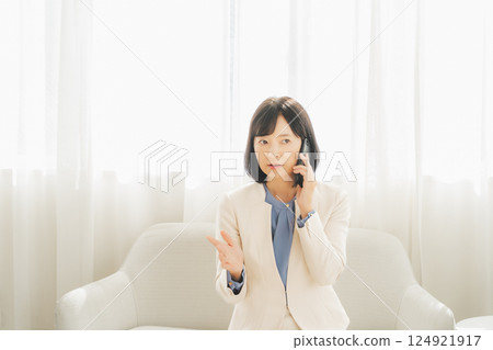 A middle-aged career woman using gestures to talk to the person on the other end of the phone 124921917