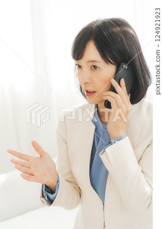 A middle-aged career woman using gestures to talk to the person on the other end of the phone A middle-aged career woman using gestures to talk to the person on the other end of the phone 124921923