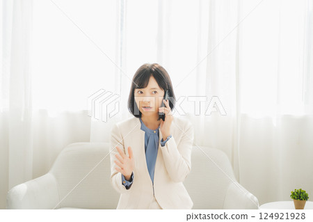 一位中年職業婦女用手勢與電話另一端的人交談 一位中年職業婦女用手勢與電話另一端的人交談 124921928