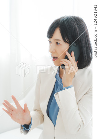 A middle-aged career woman using gestures to talk to the person on the other end of the phone A middle-aged career woman using gestures to talk to the person on the other end of the phone 124921943