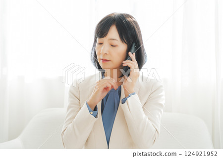 A middle-aged career woman using gestures to talk to the person on the other end of the phone 124921952