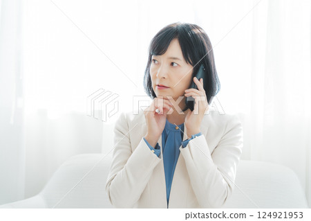 A middle-aged career woman using gestures to talk to the person on the other end of the phone 124921953