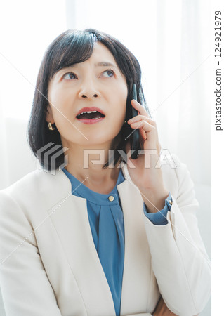 A middle-career woman struggling to communicate her thoughts to the person on the other end of the phone 124921979
