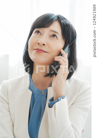 A middle-career woman struggling to communicate her thoughts to the person on the other end of the phone 124921989