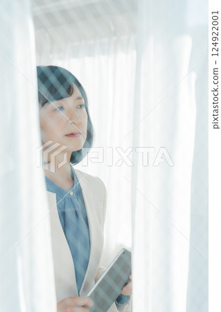 A middle-career woman looking out the window A middle-career woman looking out the window 124922001
