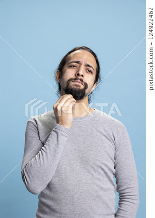 Middle eastern man being confused and uncertain in front of camera, being contemplative and reflecting about something. Unsure curious guy thinking about new ideas, introspection. 124922462