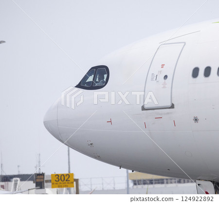 Pilot sitting in cockpit of modern white airplane on runway Pilot sitting in cockpit of modern white airplane on runway 124922892