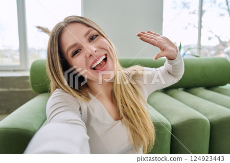 Selfie portrait happy beautiful young woman in home interior 124923443