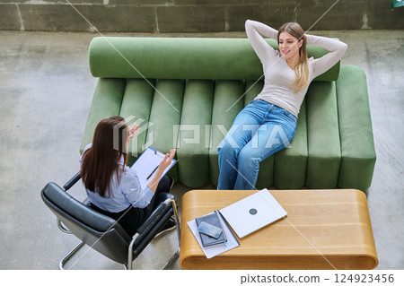 Relaxed young woman lying on sofa in psychologist office at therapy session Relaxed young woman lying on sofa in psychologist office at therapy session 124923456