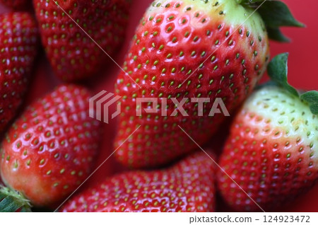 red juicy strawberries on a green background, summer photo background of strawberries as a background	 124923472