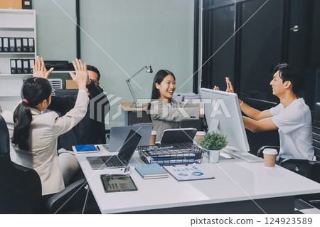 Cheerful meeting room, businesspeople celebrate with handshaking. Successful project was completed before the deadline. Business partnership and collaboration in project management. Habiliment Cheerful meeting room, businesspeople celebrate with handshaking. Successful project was completed before the deadline. Business partnership and collaboration in project management. Habiliment 124923589