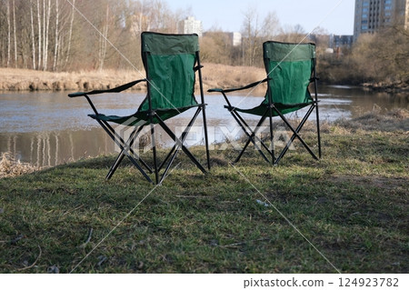 Two folding chairs for camping on the river bank. Fishing and outdoor recreation 124923782