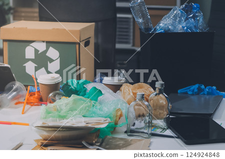 Close-up of female hands from a family collecting plastic waste and bottles from the ground. They wear gloves and focus on recycling to help reduce plastic pollution and protect the environment. 124924848