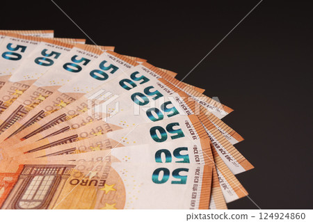 50 euro bills on a black background, arranged in a fan. Studio shooting. 124924860