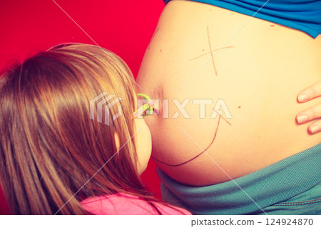 Toddler girl drawing on mother pregnant belly 124924870