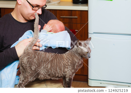 Newborn baby held by father and cat 124925219