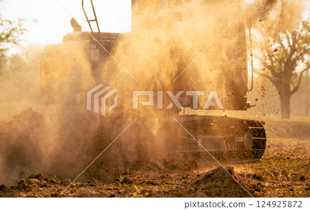 Hydraulic excavator operating at a worksite, moving earth and preparing the foundation for a major construction project. Heavy equipment plays a key role in engineering, roadwork, and excavation. 124925872
