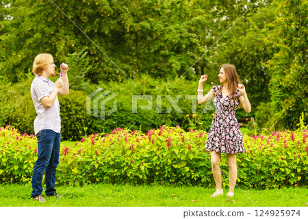 Couple blowing bubbles outdoor 124925974