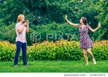 Couple blowing bubbles outdoor 124925975