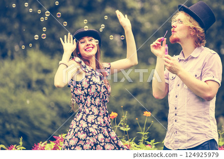 Couple blowing bubbles outdoor Couple blowing bubbles outdoor 124925979