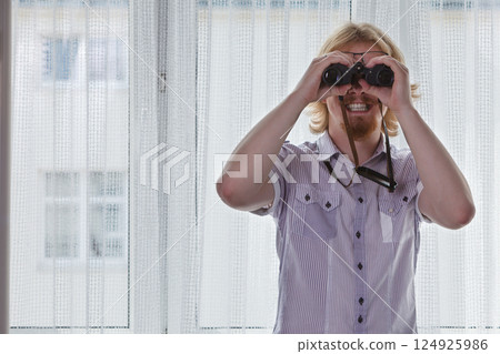 Man with binoculars spying on neighbors Man with binoculars spying on neighbors 124925986