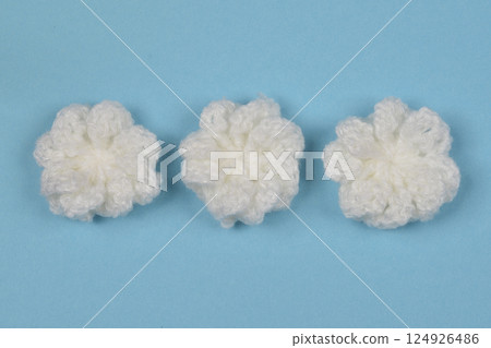 Three white crocheted flowers 124926486
