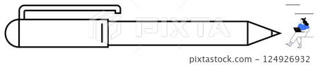 Oversized, outlined ballpoint pen stretches across frame while person in blue sweater works on laptop in the distance. Ideal for contrasting scale, creativity, study themes, technology, unusual 124926932