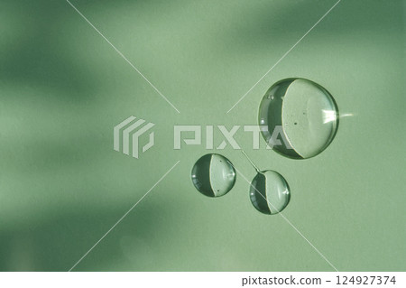 A drop of micellar water on a green background. A drop of micellar water on a green background. 124927374