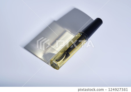 Bottle with brush filled with oil for eyebrow and eyelash growth.  124927381