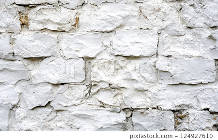 A white-painted brick wall with distinct textures and horizontal alignment, giving a clean yet rustic aesthetic. 124927610