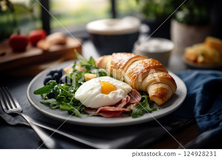 A rustic croissant filled with poached egg, ham, and arugula, illuminated by soft natural window light. The light highlights the layers and creates gentle shadows, adding depth and warmth 124928231