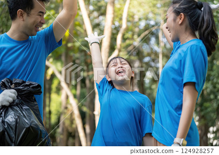 Joyful family celebrating after a successful volunteer garbage collection in the park 124928257