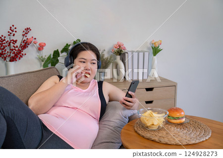 Satisfying sweet cravings overweight woman enjoys dessert at home cozy environment relaxed viewpoint Satisfying sweet cravings overweight woman enjoys dessert at home cozy environment relaxed viewpoint 124928273