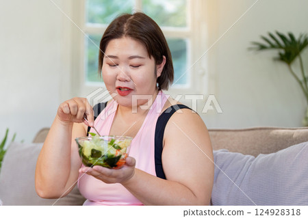 Overweight woman enjoying healthy food at home weight loss journey lifestyle change relaxed environment self care concept Overweight woman enjoying healthy food at home weight loss journey lifestyle change relaxed environment self care concept 124928318