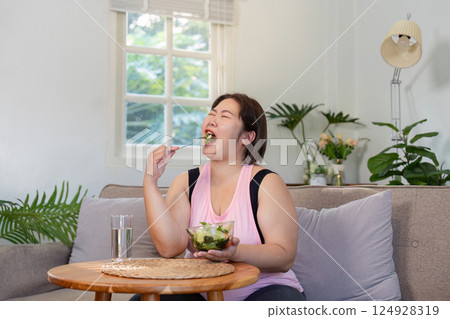 Overweight woman enjoying healthy food at home lifestyle change journey indoor relaxation focus on weight loss Overweight woman enjoying healthy food at home lifestyle change journey indoor relaxation focus on weight loss 124928319