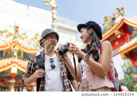 Traveling couple captures moments in colorful cultural environment vibrant festival outdoor viewpoint joyful exploration 124928354