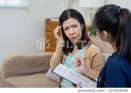 Caregiver checks symptoms of elderly patient with doctor in nursing environment close up view health assessment concept Caregiver checks symptoms of elderly patient with doctor in nursing environment close up view health assessment concept 124928446