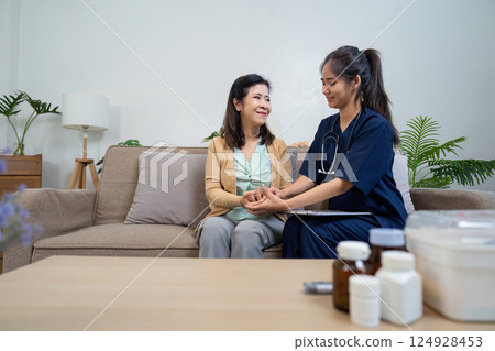 Caregiver checks symptoms of elderly patient with doctor and nurse in home environment 124928453