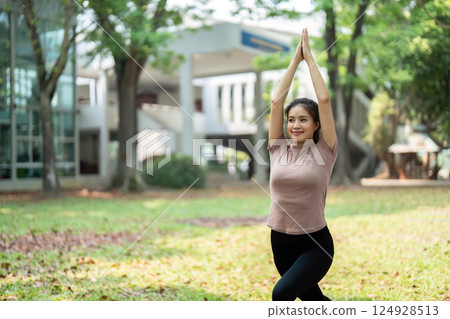 Wellness and Fitness Routine. A woman practicing yoga outdoors, enhancing her physical and mental well-being. Wellness and Fitness Routine. A woman practicing yoga outdoors, enhancing her physical and mental well-being. 124928513
